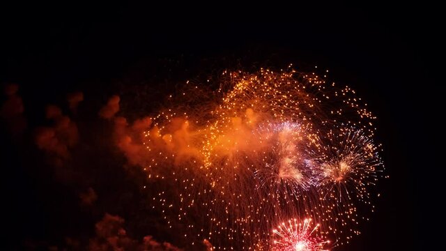 4K.Real fireworks background. Shining fireworks in the night sky. Glowing sparkles. New year's eve fireworks celebration. Colorful New Year Firework 