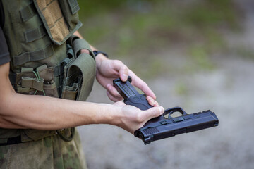 Close up of a man reloading an airsoft pistol