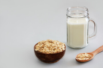 white milk drink in a mug and dry oat flakes