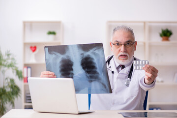 Old male doctor radiologist working in the clinic