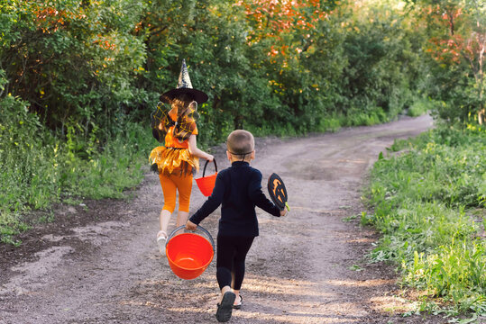 Children in costumes are running for sweets for the holiday. Concapt of Halloween, Traditions.