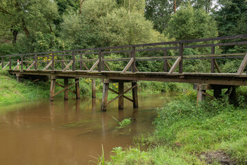 Drewniany most nad małą rzeką. - obrazy, fototapety, plakaty