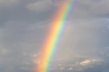 Real rainbow on a background of cloudy sky.