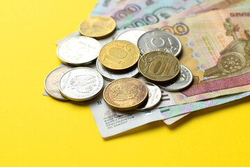 Russian rubles on a yellow background. Banknotes and  various coins.