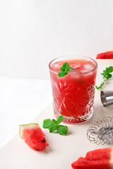 Watermelon mojito with ice and mint in the drinking glass against the white background. Refreshing summer drink