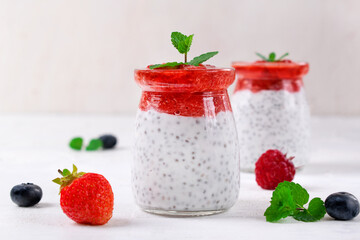 Chia pudding with coconut milk and strawberry puree served in the glass jar. Healthy layered dessert. Vegan food
