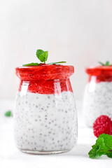 Chia pudding with coconut milk and strawberry puree served in the glass jar. Healthy layered dessert. Vegan food