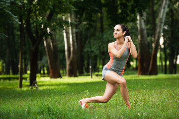 full length of young sportswoman with clenched hands exercising in park