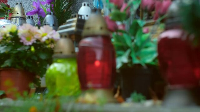 Flowers and Glass Lantern Candles and Cemetery Columbarium Funeral Urn Wall Before All Saints Day