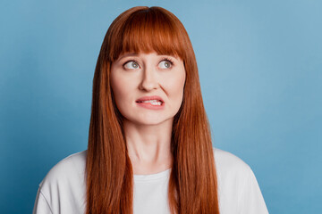 Photo of girl bite lip sorry guilty expression think isolated on blue background
