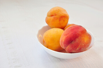 Tasty juicy peaches close up on whine table cloth, free space for ypur text