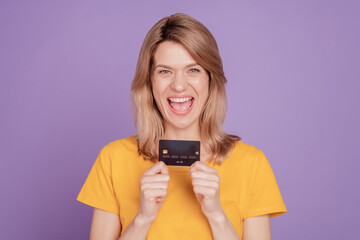 Fototapeta premium Photo of young attractive excited woman happy positive smile credit card money income isolated on violet color background