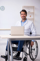 Fototapeta na wymiar Young male doctor in wheel-chair working in the clinic