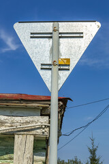 Back side of old aluminum road sign against sky background