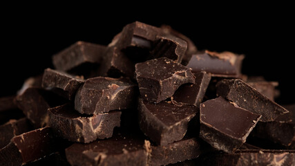 Chocolate. Chunks of dark chocolate rotate on dark background. Gourmet dessert ingredient. Confectionery, confection concept