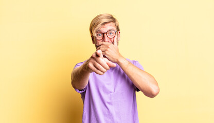 handsome blond adult man laughing at you, pointing to camera and making fun of or mocking you
