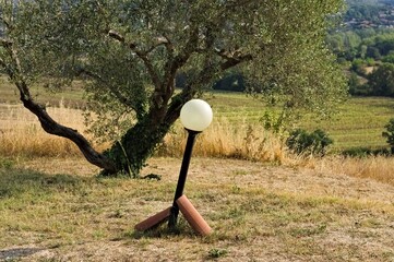 A crooked street lamp in the garden (Umbria, Italy, Europe)