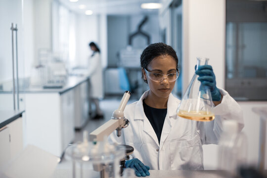 African american female scientist looking at microscope