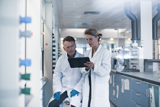 Scientists looking at results of experiment on a digital tablet