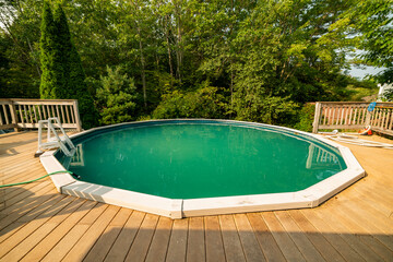 Home pool. A small rubber swimming pool with a deck in an home backyard