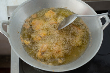 Unhealthy diet. Deep fried chicken of top view. Golden color fried chicken in the hot boiling oil being cooked at home. 