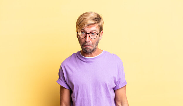handsome blond adult man feeling sad and whiney with an unhappy look, crying with a negative and frustrated attitude