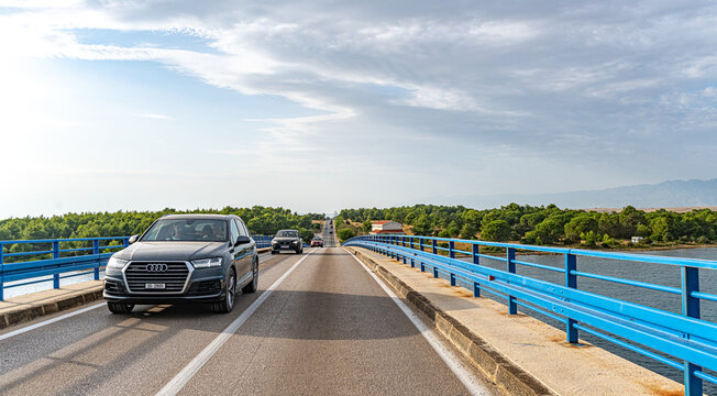 Vir, Croatia - July 27, 2021: A black Audi Q7 rides across a transport bridge on the island of Vir, Croatia.