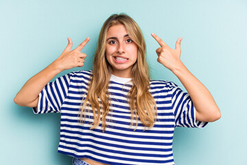 Young caucasian blonde woman isolated on blue background  showing a disappointment gesture with...