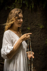 Caucasian woman keeping count during pray and meditation. Buddhist japa mala. Strands of gemstones...
