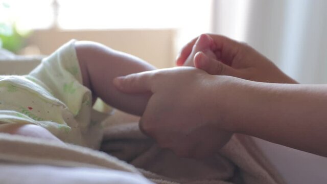 Mother touches baby's feet softly