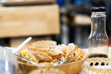 Food scraps in a wooden plate lying on the dining table.