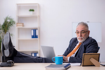 Old male employee missing his wife at workplace