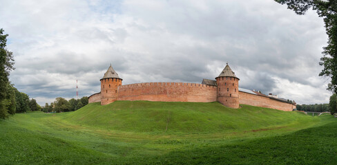 Fototapeta na wymiar Panorama view of walls and Fyodorovskaya and Mitropolichya towers of Novgorod Kremlin. Summer cloudy day in Veliky Novgorod, Russia.
