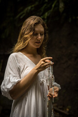Caucasian woman keeping count during pray and meditation. Buddhist japa mala. Strands of gemstones...
