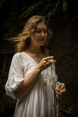 Caucasian woman keeping count during pray and meditation. Buddhist japa mala. Strands of gemstones...