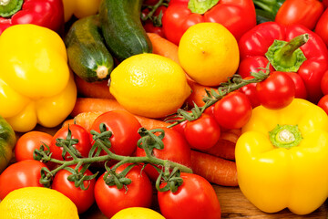 Fototapeta na wymiar Fresh seasonal vegetables tomatoes carrots lemons and peppers