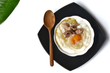 Pork porridge with eggs in a black plate