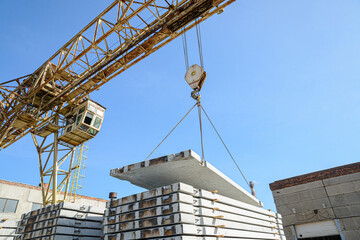 The gantry crane moves the reinforced concrete road slab. Factory warehouse