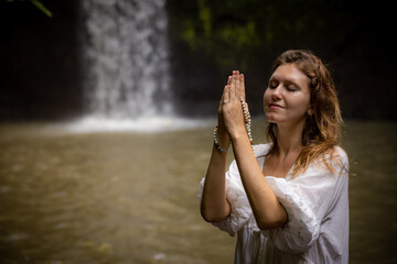 Caucasian woman holding mala for pray and meditation. Buddhist japa mala. Hands in namaste mudra....