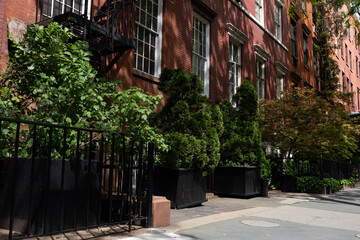 Neighborhood Sidewalk in Greenwich Village of New York City with Green Plants and Colorful Buildings during Spring