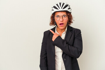 Middle age latin business woman wearing a bike helmet isolated on white background pointing to the side