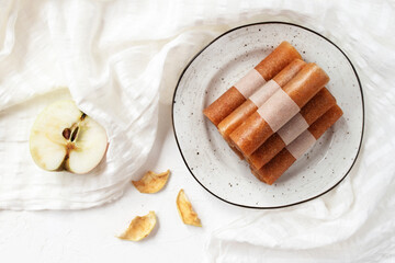 Pastille fruit rolls, apple marshmallow on a plate and white tablecloth. Healthy sweets.