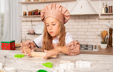a small charming brunette sculpts figures from the text on the background of the kitchen of the house