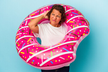 Middle age latin woman with air mattress isolated on white background touching back of head, thinking and making a choice.