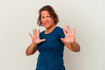 Middle age latin woman isolated on white background rejecting someone showing a gesture of disgust.
