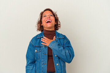 Middle age latin woman isolated on white background laughs out loudly keeping hand on chest.