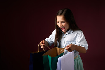 happy little child girl holds many shopping bags