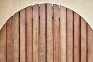 Round table top made of wooden slats for outdoor table lying on dusty floor in workshop close upper...