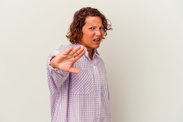 Middle age latin woman isolated on white background rejecting someone showing a gesture of disgust.