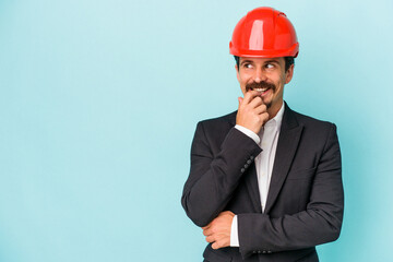 Young architect caucasian man isolated on blue background relaxed thinking about something looking at a copy space.